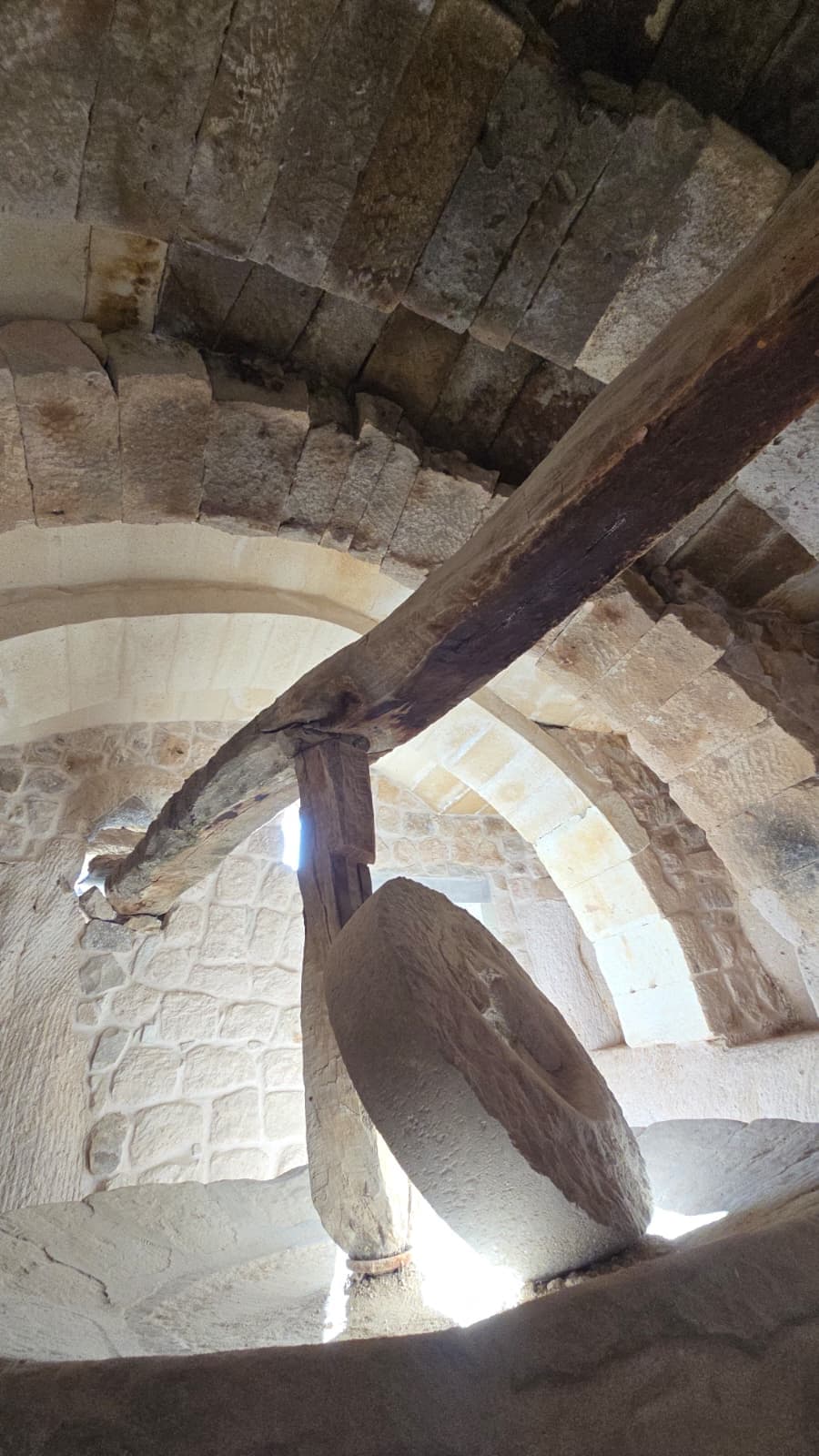 A heritage millstone within a vaulted cave room