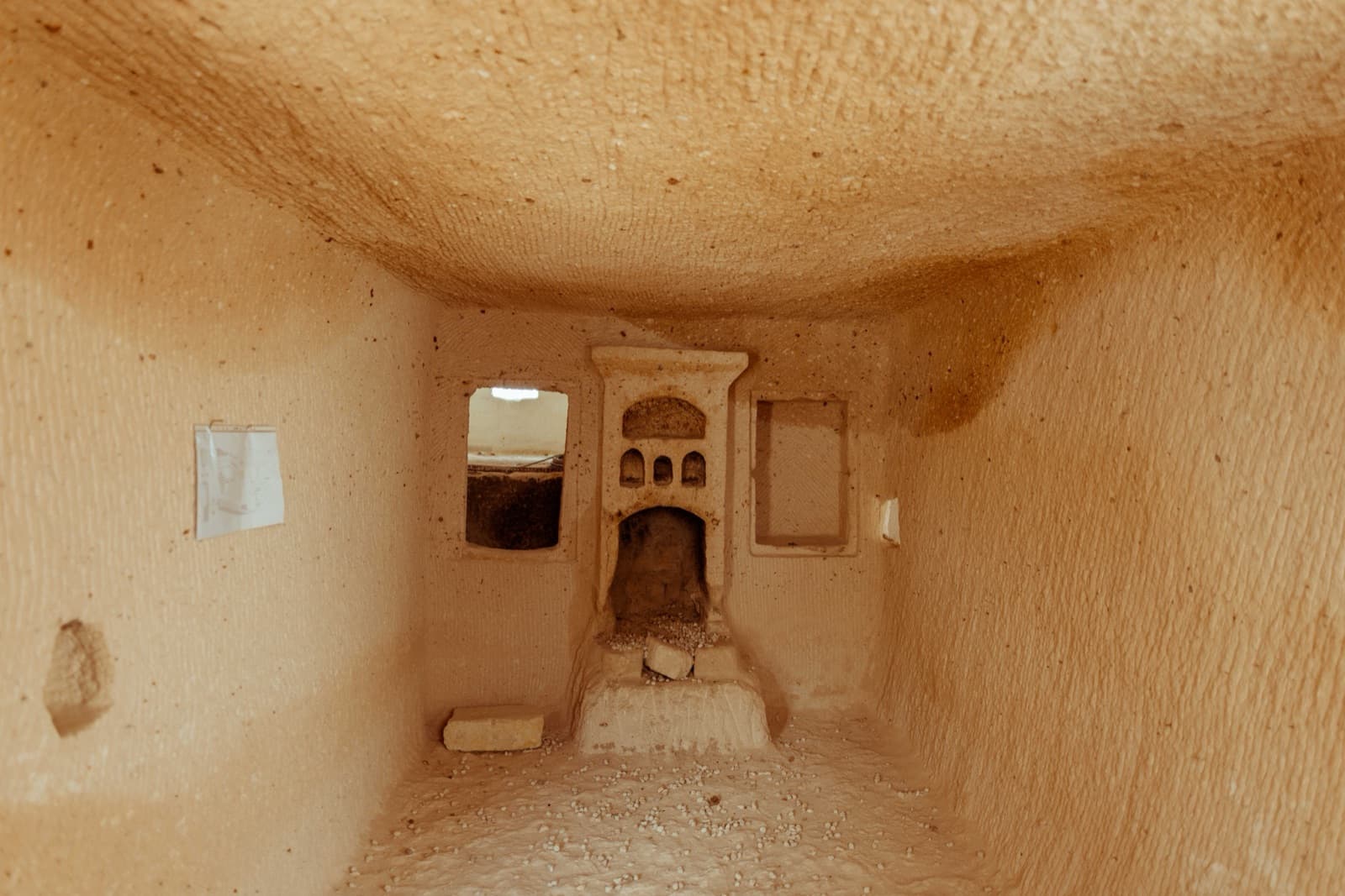 A carved fireplace and niche within a cave-suite room