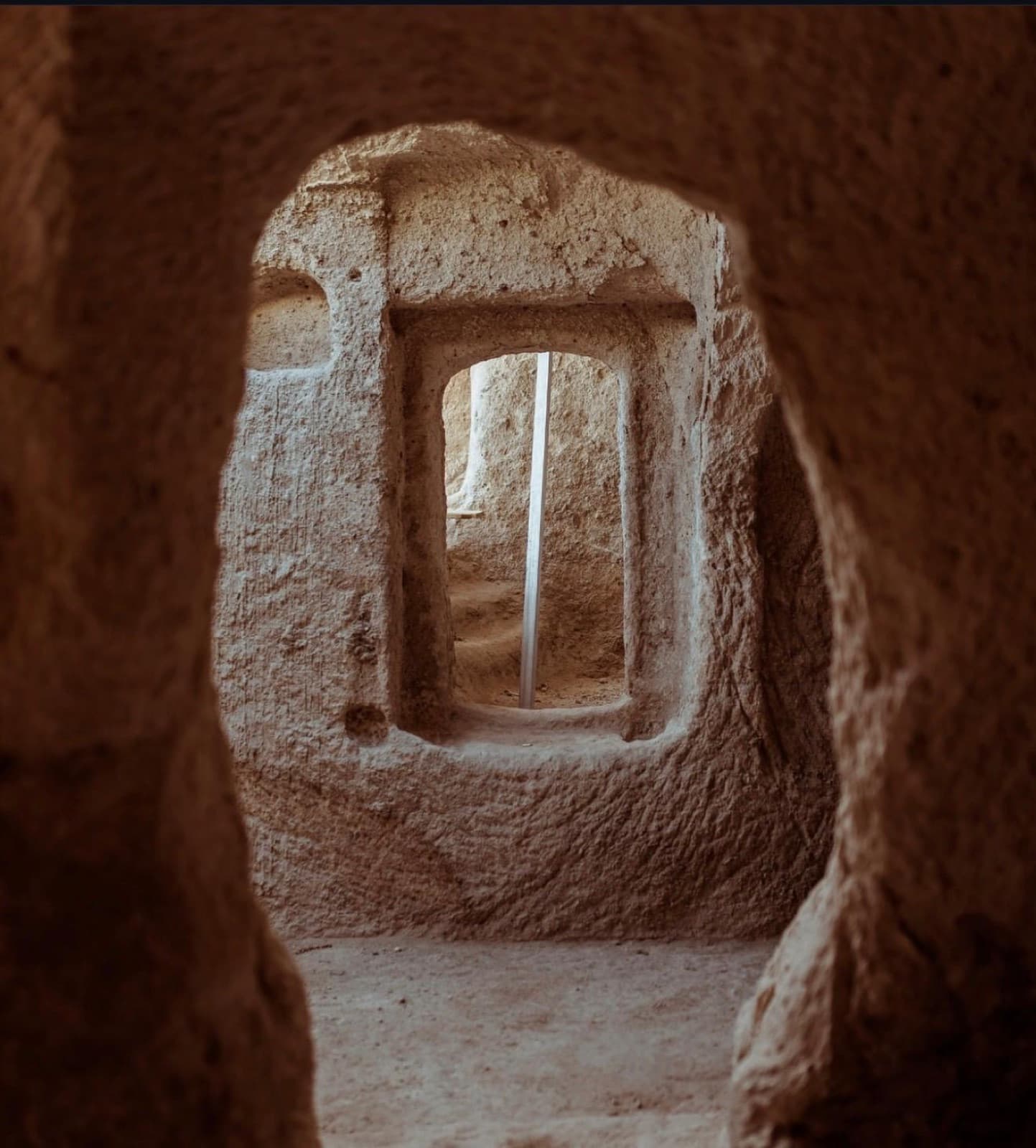 Arched window carved into the stone of a cave suite
